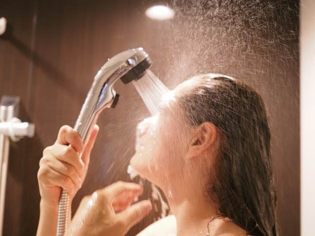 勢いよくシャワーを浴びる女性　写真
