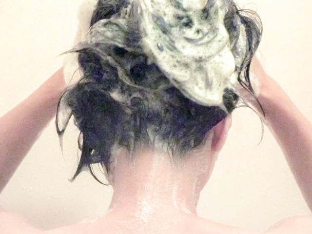 自分で髪を洗う女性　写真
